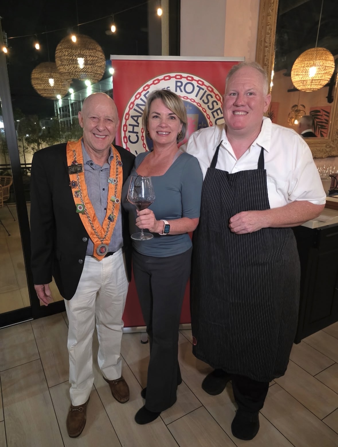 Members beside the Chaîne banner with the evening's chef